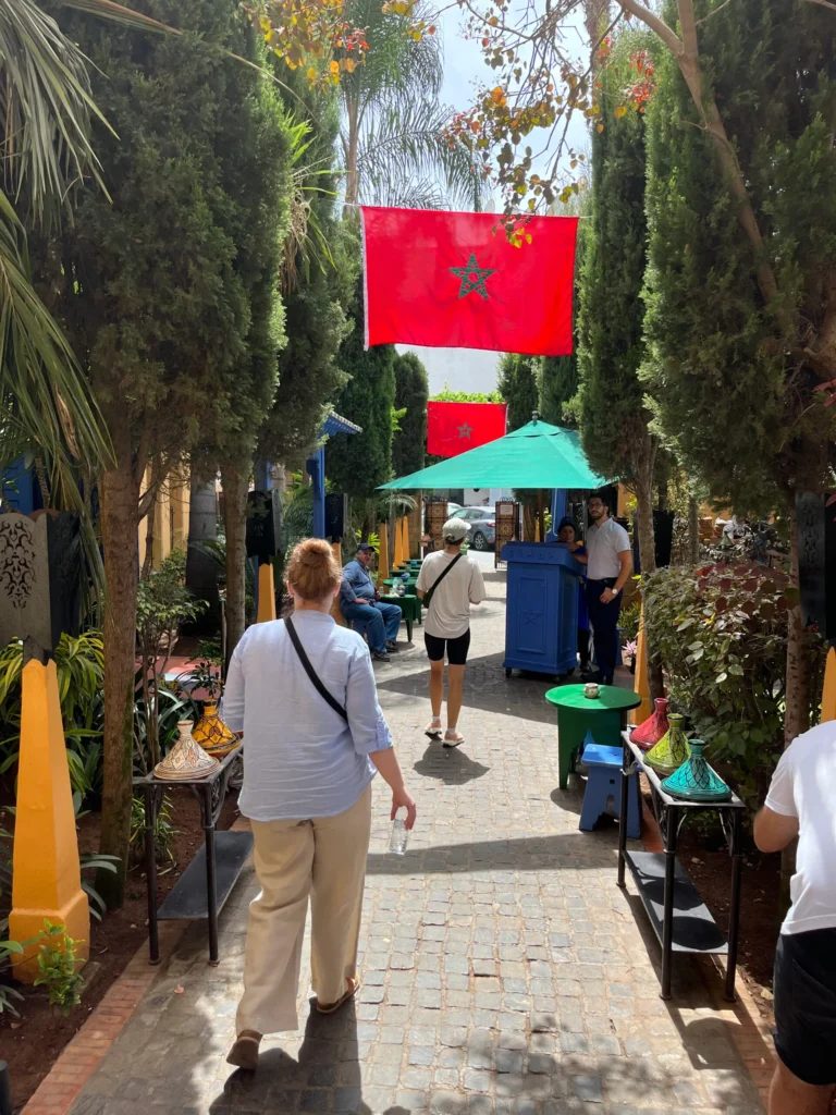 Tourists walking through a narrow street lined with Moroccan flags in Casablanca