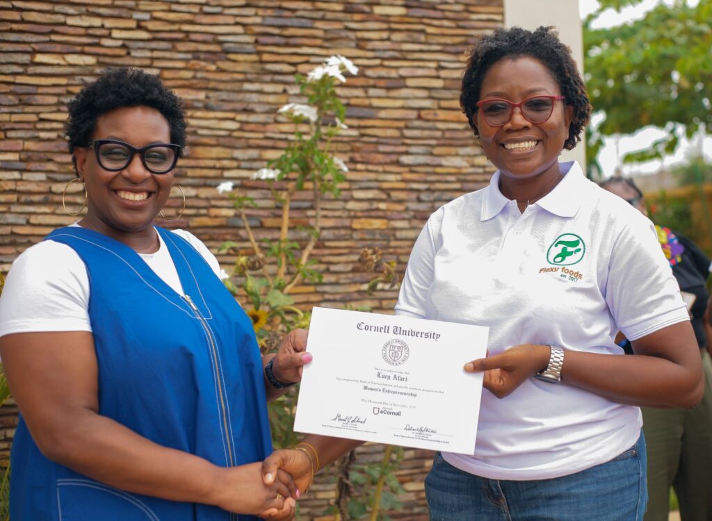 Two women celebrating a Cornell University certificate award in Ghana.