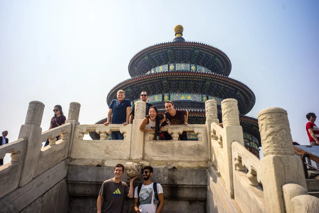 Group of tourists smiling in front of the Temple of Heaven in Beijing, China.